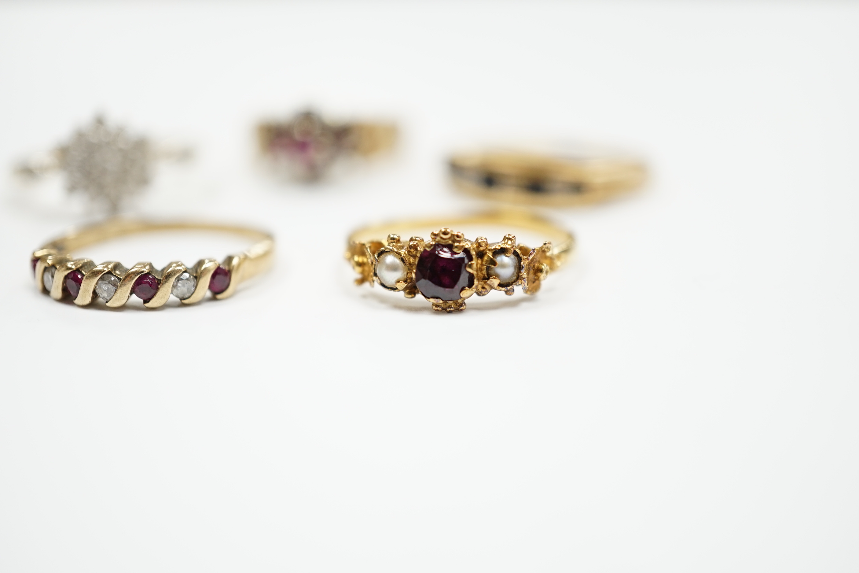 Three assorted 9ct gold and gem set rings, including ruby and diamond cluster, gross weight 7.7 grams, a 585 yellow metal and cubic zirconia set cluster ring and a yellow metal, garnet and seed pearl set ring, gross weig